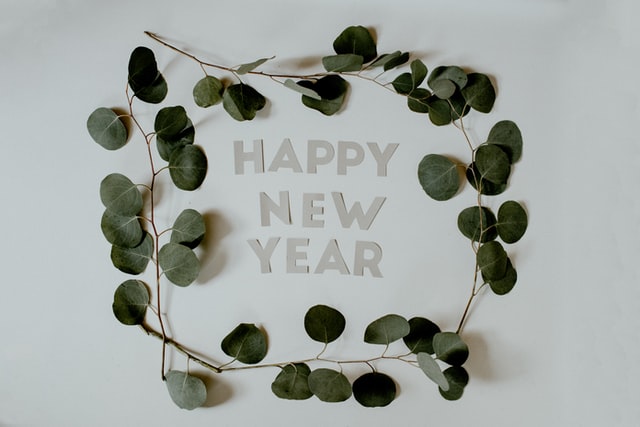 Happy New Year inside a circle of small eucalyptus branches & leaves.